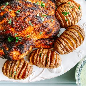 Photograph Skillet Roast Peri Peri Chicken with Coriander and Chilli Yoghurt and Hasselback Potatoes