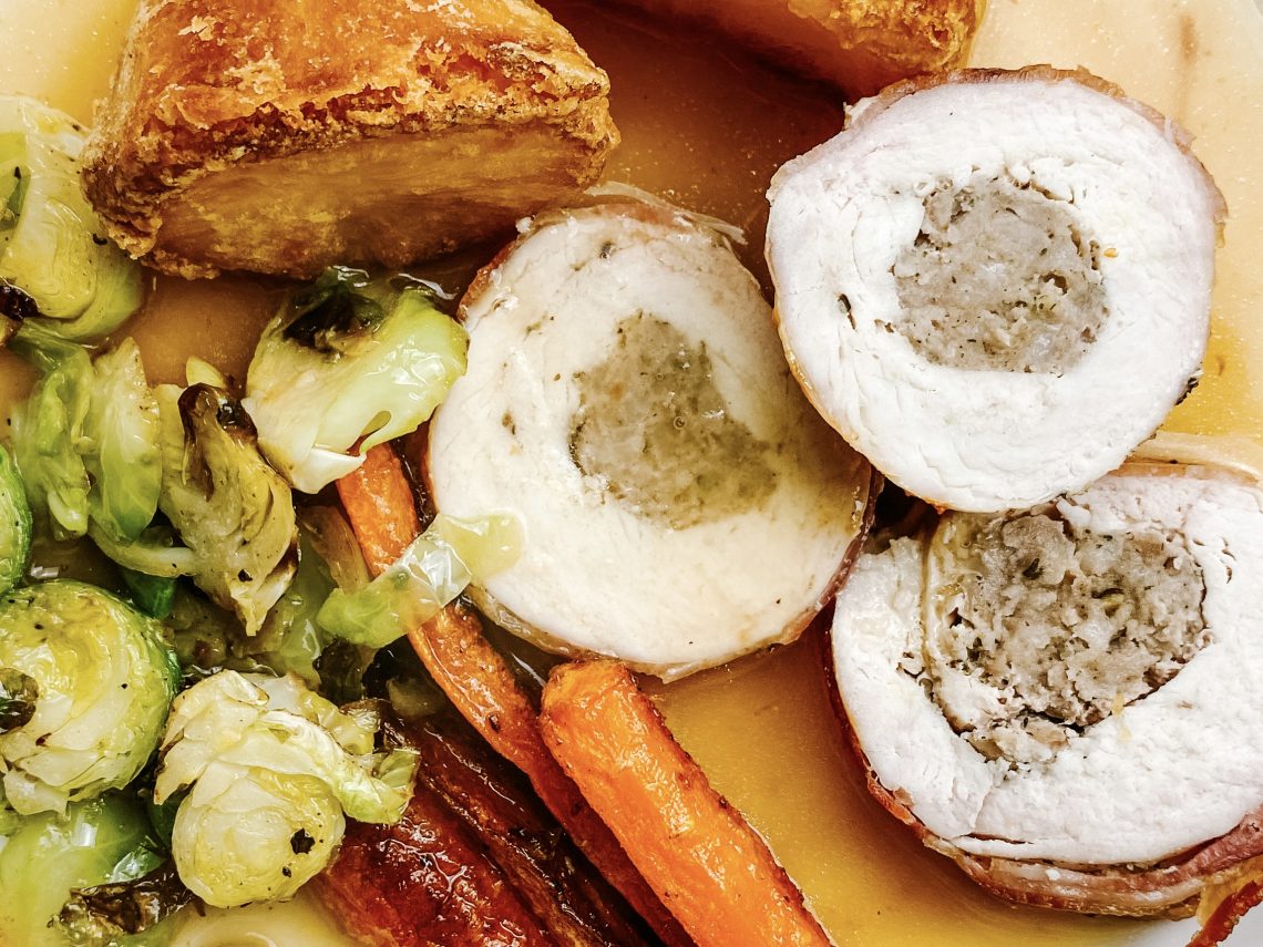 Photograph of Chicken Breast Roast Dinner with Sausages, Roast Potatoes, Roast Carrots, Shredded Brussels Sprouts and Gravy