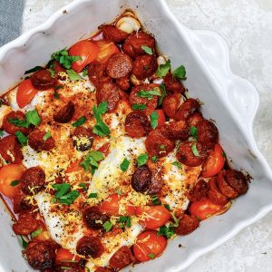 Photograph of Smoked Paprika Baked Hake with Chorizo, Lemon, Tomatoes and Garlic