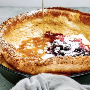 Photograph of German Pancake with Blueberry Compote, Natural Yoghurt and Maple Syrup