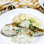 Photograph of Halibut Fillets Coated with Crispy Pistachio and Served with a Creamy Lemon and Parsley Sauce