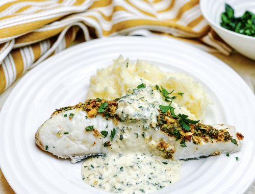 Photograph of Halibut Fillets Coated with Crispy Pistachio and Served with a Creamy Lemon and Parsley Sauce