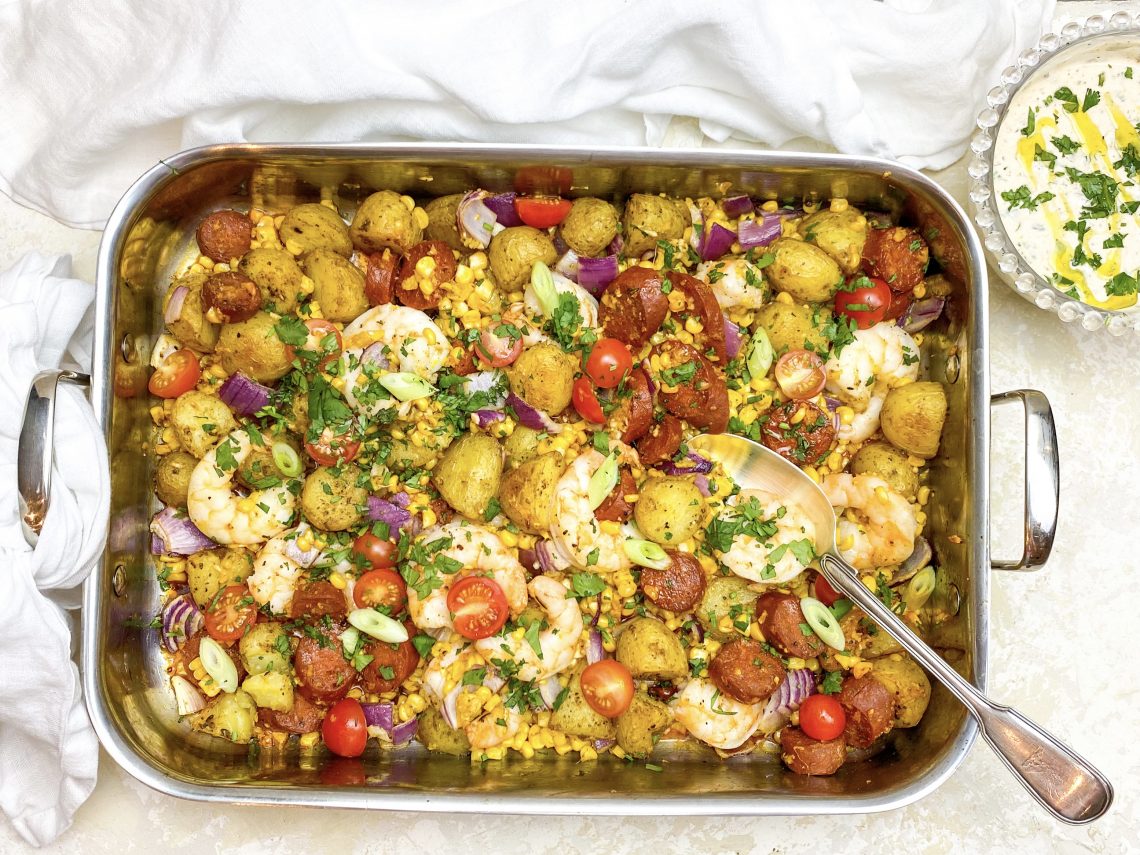 Photograph of Sheet Pan Old Bay Prawns, Chorizo Sausage, New Potatoes and Sweetcorn Served with a Garlic and Lemon Yoghurt Dressing