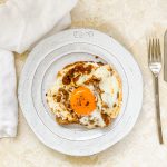 Photograph of Pesto Fried Egg on Toast with Ricotta Cheese and Smoked Chilli Flakes