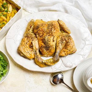 Photograph of Roast Spatchcock Chicken and Gravy with New Potatoes Cooked in Chicken Stock