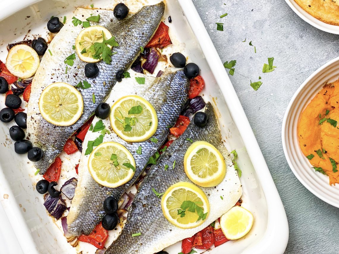 Photograph of Oven-Baked Sea Bass with Red Onion, Red Pepper, Black Olives and Lemon