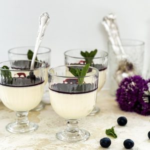 Photograph of White Chocolate Panna Cotta with Blueberry and Blackberry Coulis