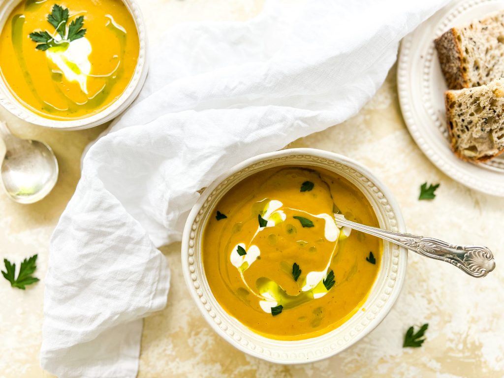 Photograph of Carrot and Onion Squash Soup with Parsley Oil and Sour Cream
