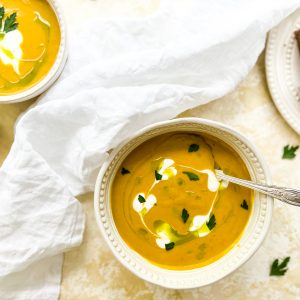 Photograph of Carrot and Onion Squash Soup with Parsley Oil and Sour Cream